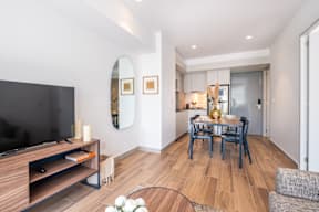a living room and dining room with a table and a television