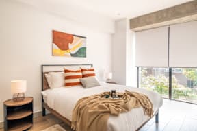 a bedroom with a bed and a large window