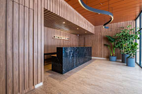 the lobby of a hotel with a black reception desk