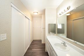 A bathroom with a sink, mirror, and a white vanity.
