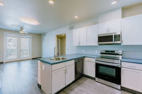 a kitchen with white cabinets and a sink and a stove