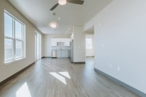 the living room and kitchen in a new home with white walls and wood flooring