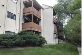 an apartment building with two balconies and a yard