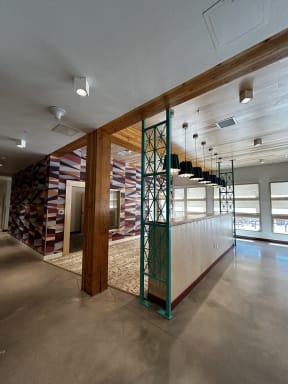 a lobby with a bar and a geometric wall with hanging lights