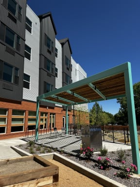 an outdoor area with a fire pit in front of an apartment building