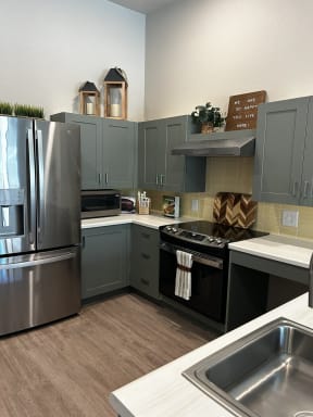 a kitchen with stainless steel appliances and gray cabinets