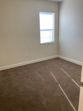 an empty room with carpet and a window