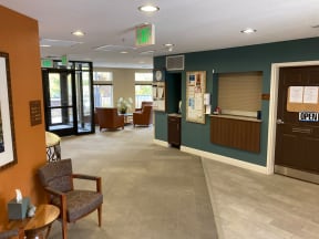 a lobby of a hospital with chairs and a reception desk