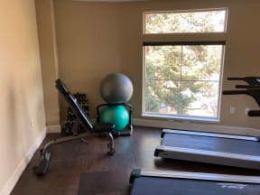 a home gym with exercise equipment and a large window