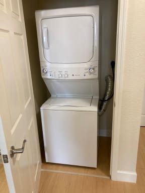 a white washer and dryer in a small closet