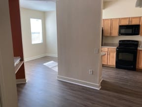 a view of a living room and a kitchen with wood floors