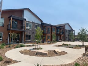 an exterior view of an apartment complex with walkways and landscaping