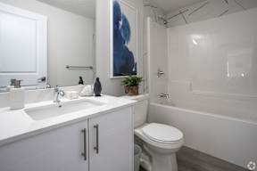 A white bathroom with a toilet, sink, and bathtub.at Hills on 36, Alberta