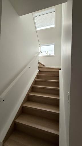 A staircase with a skylight above it.