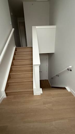 A staircase with a white railing and wooden steps.