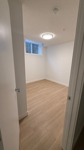 A room with a window and a wooden floor.