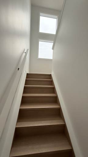 A staircase with a skylight above it.