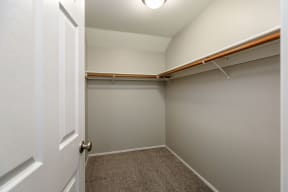 a walk in closet with a white door and gray walls