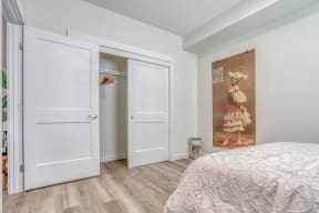 a bedroom with white doors and a large painting on the wall