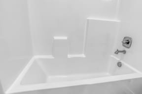 a white bathtub with a silver faucet