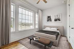 a bedroom with a bed and a large window