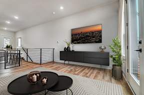 an open living room with a tv on the wall and a table and chairs