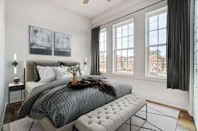 a bedroom with a bed and three windows