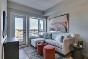 a living room with a gray couch and a large painting on the wall