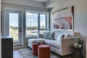 a living room with a gray couch and a large painting on the wall