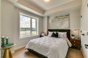 a bedroom with a large bed and two windows