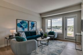 a living room with a blue couch and two chairs