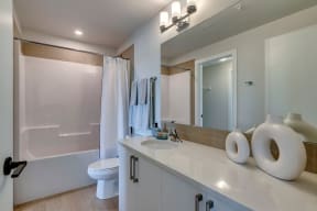 a bathroom with a toilet sink mirror and shower
