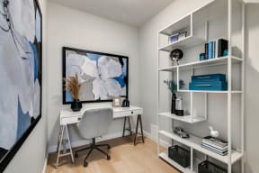 a home office with a white desk and a large painting on the wall