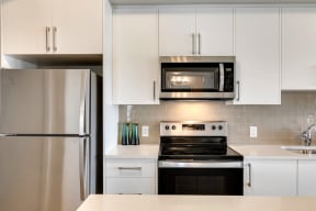 a kitchen with white cabinets and stainless steel appliances