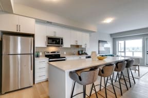 a kitchen with white cabinets and a large island with a white countertop