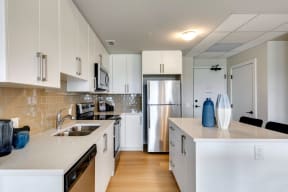 a kitchen with white cabinets and stainless steel appliances