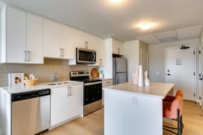 a kitchen with white cabinets and stainless steel appliances
