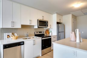 a kitchen with white cabinets and stainless steel appliances