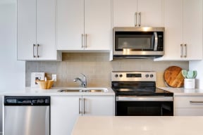 a kitchen with white cabinets and stainless steel appliances