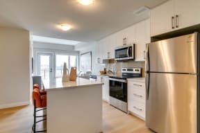 a kitchen with white cabinetry and stainless steel appliances