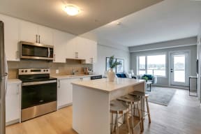 a kitchen with white cabinets and a white island with three stools