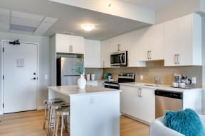 a kitchen with white cabinets and a white island with a white vase on top of it