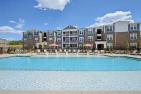 a swimming pool with an apartment building in the background