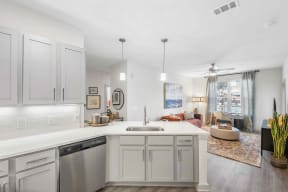 a kitchen with white cabinets and white countertops and a living room with a couch south twenty cartersville ga