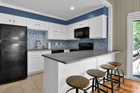 a kitchen with a large island with four stools in front of it