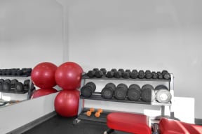 a gym with weights and a red chair