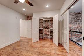 A room with a brick wall and wooden flooring.