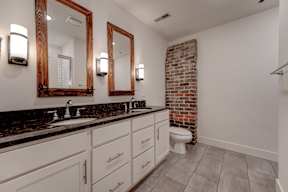A bathroom with a brick wall and a toilet.