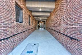 A long corridor with brick walls and a concrete floor.