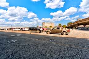 A parking lot with cars and a building in the background.
